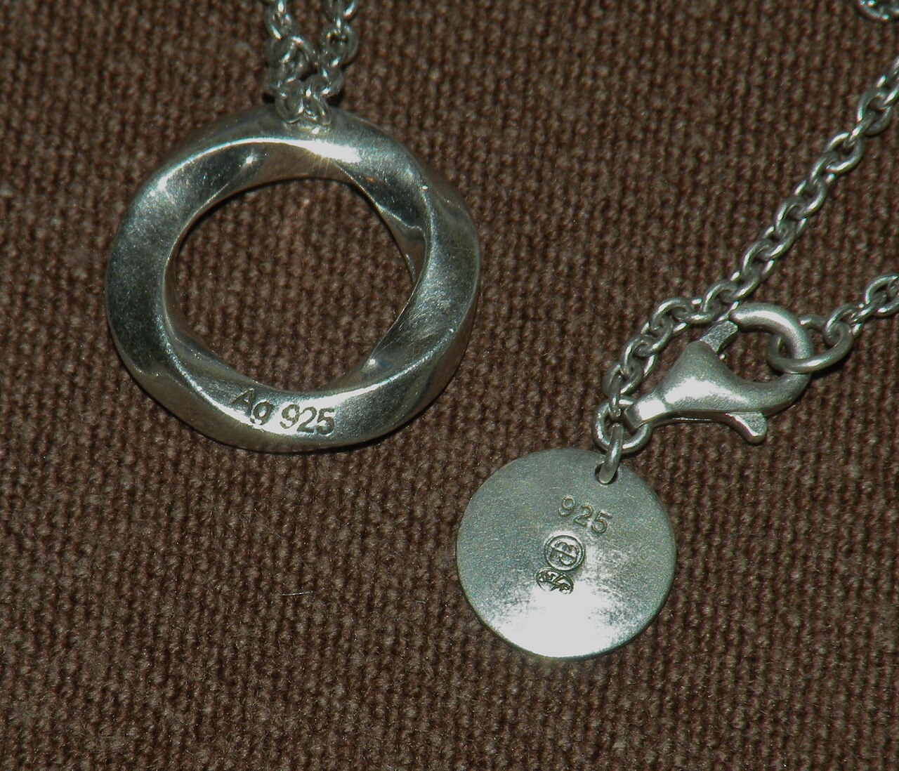Close-up photograph of a 925 mark stamped on a silver necklace component