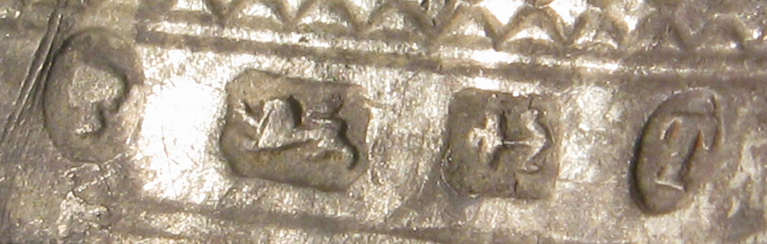 Close-up photograph of worn Birmingham marks on a nineteenth-century silver thimble